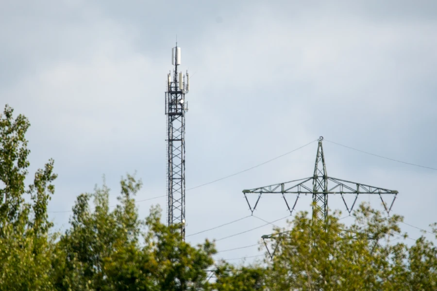 Funkmast auf dem Land neben Stromtrasse